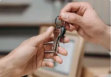 Handing over a keyring with multiple keys between two people.