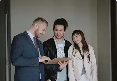 Man showing couple a document inside a modern apartment.